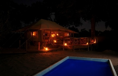 View of pool at tented accommodation at night, Linyanti Ebony Camp