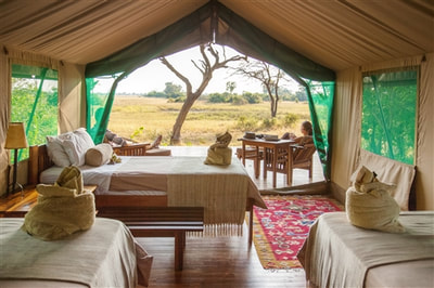 Interior of tented accommodation with view at Macatoo Camp